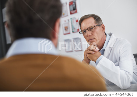 Adult doctor in white coat communicates with patient 44544365