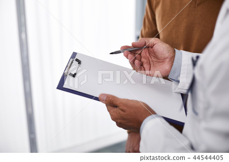 Doctor is holding form in his hand Doctor is holding form in his hand 44544405