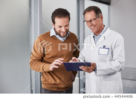 Smiling doctor showing man documents with recommendations 44544406