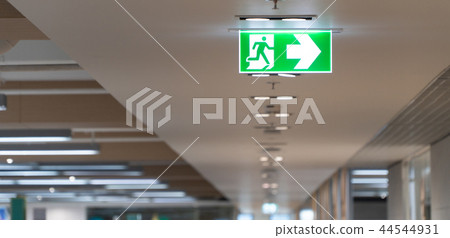 Green fire escape sign hang on the ceiling 44544931