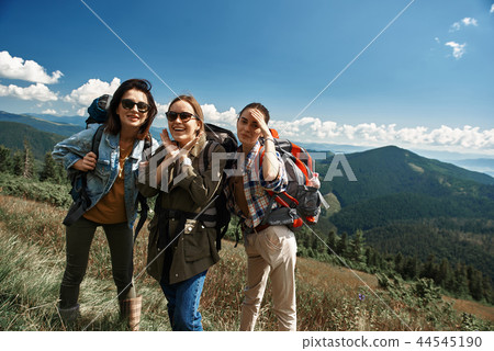 Smiling women are travelling through highland together Smiling women are travelling through highland together 44545190