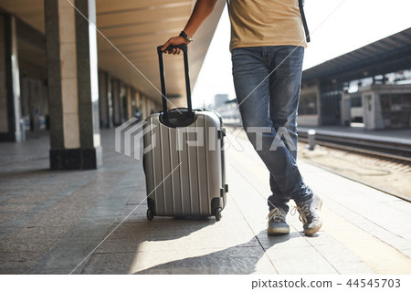 Low angle of a man carrying his luggage 44545703