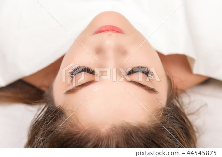 Eyelash Extension Procedure. Woman Eye with Long Eyelashes. Close up, selective focus. Eyelash Extension Procedure. Woman Eye with Long Eyelashes. Close up, selective focus. 44545875