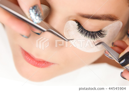 Eyelash Extension Procedure. Woman Eye with Long Eyelashes. Close up, selective focus. 44545904