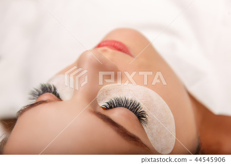 Eyelash Extension Procedure. Woman Eye with Long Eyelashes. Close up, selective focus. 44545906