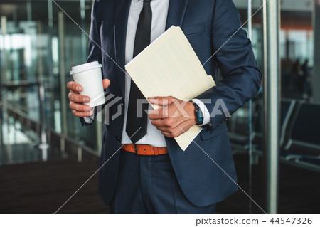 Busy man with paper cup and data 44547326