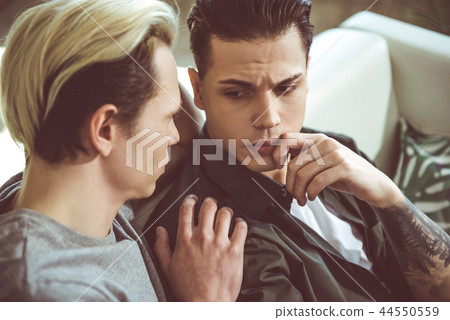 Loving boyfriend touching shoulder of sad young man 44550559