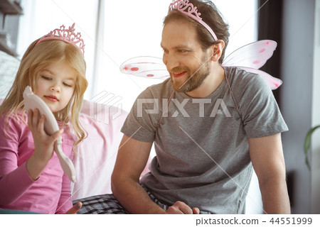 Cheerful daughter doing make-up for her dad Cheerful daughter doing make-up for her dad 44551999