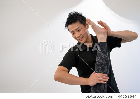 Gym trainer doing leg stretching (female feet) 44552644