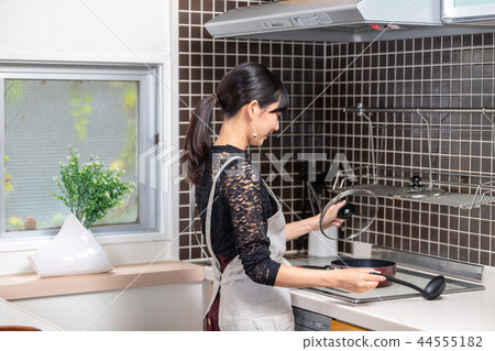Young woman standing in the kitchen Young woman standing in the kitchen 44555182