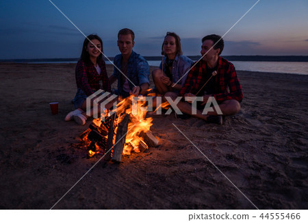 young friends have picnic with bonfire on the beach 44555466