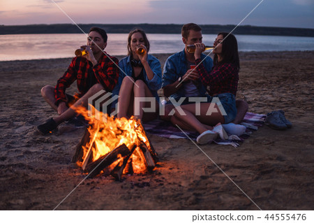 young friends have picnic with bonfire on the beach 44555476