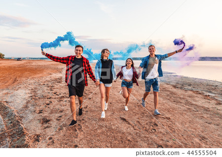 young friends running with hand flare or fusee young friends running with hand flare or fusee 44555504