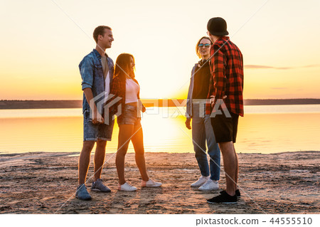 couple friends on beach together walking during sunset couple friends on beach together walking during sunset 44555510