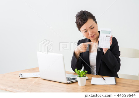 An angry woman holding a calculator 44559644