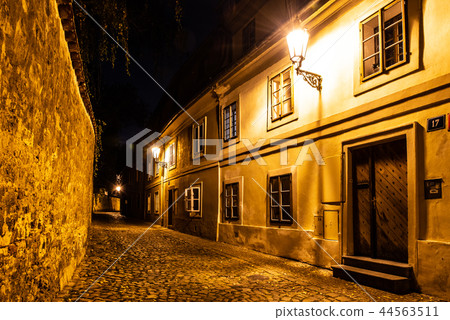 Narrow cobbled street in old medieval town with illuminated houses by vintage street lamps, Novy 44563511