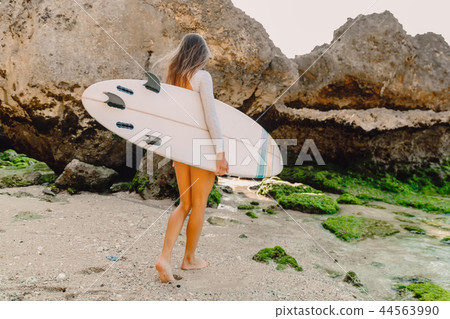 Surf woman with surfboard going to ocean Surf woman with surfboard going to ocean 44563990