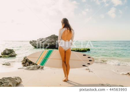Beautiful sexy surfer girl on a sand beach Beautiful sexy surfer girl on a sand beach 44563993