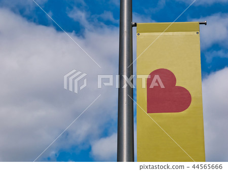 Flagpole with red heart on a yellow banner 44565666