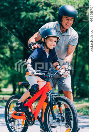 Grandfather and grandson biking in the park Grandfather and grandson biking in the park 44566794