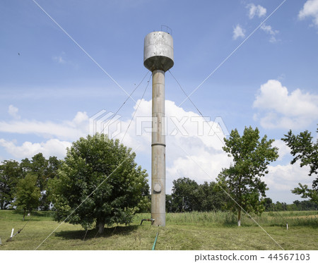 Silver Water Tower among green grass and trees Silver Water Tower among green grass and trees 44567103