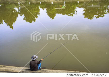Man fishing along the river banks. 44567247