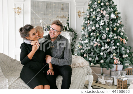 Happy family having fun at home. Christmas morning in bright living room. Young parents with little Happy family having fun at home. Christmas morning in bright living room. Young parents with little 44568693