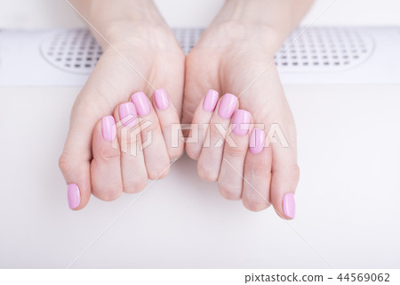 Gentle pink manicure. Female hands manicure salon 44569062