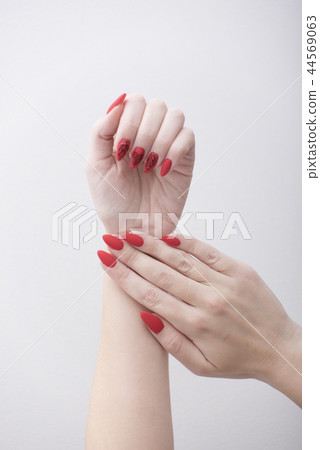 Red manicure with a pattern. Female hands 44569063