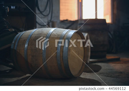 Wooden barrels in the old cellar in winery. barrels for wine with steel ring Wooden barrels in the old cellar in winery. barrels for wine with steel ring 44569112