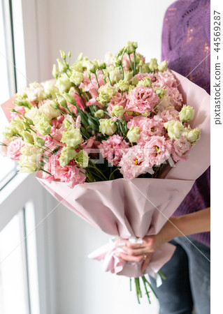 beautiful spring bouquet. Young girl holding a flowers arrangement with lisianthus of pink colors 44569287
