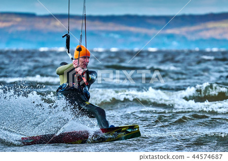 A male kiter slides on the surface of the water. A male kiter slides on the surface of the water. 44574687