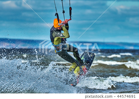 A male kiter slides on the surface of the water.  44574691