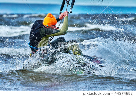 A male kiter slides on the surface of the water.  44574692