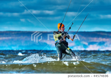 A male kiter slides on the surface of the water.  44574696