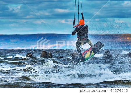 A male kiter jumps over a large lake. Close-up. A male kiter jumps over a large lake. Close-up. 44574945