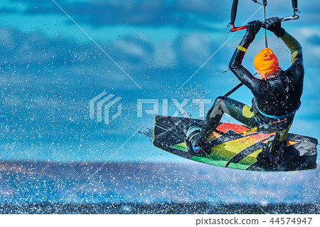 A male kiter jumps over a large lake. Close-up. 44574947