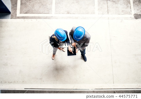 A top view of an industrial man and woman engineer with tablet in a factory, working. 44575771