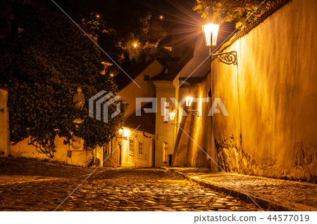 Narrow cobbled street in old medieval town with illuminated houses by vintage street lamps, Novy Narrow cobbled street in old medieval town with illuminated houses by vintage street lamps, Novy 44577019