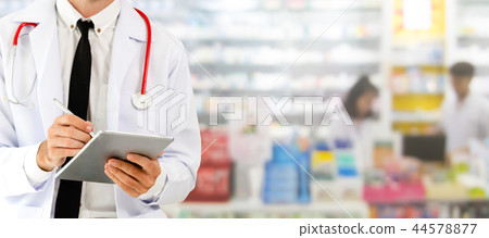 Pharmacist using tablet computer at pharmacy. 44578877