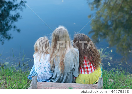 children on the riverbank / summer vacation merry girlfriends on vacation, sisters together on the river, friendship happiness family children on the riverbank / summer vacation merry girlfriends on vacation, sisters together on the river, friendship happiness family 44579358