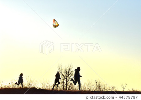 Family with kite flying and first sunrise 44579787