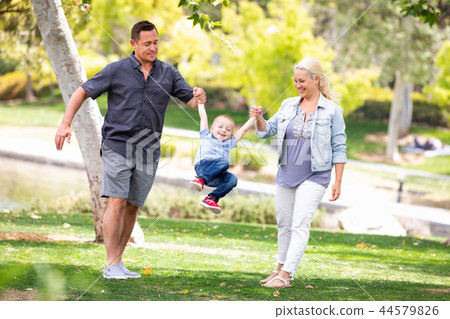 Young Mother and Father Swingging Their Son At The Park 44579826