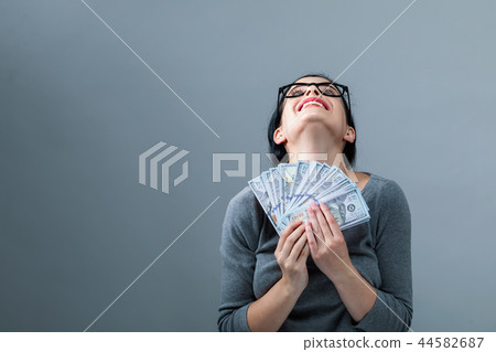 Young woman with a stack of cash USD Young woman with a stack of cash USD 44582687
