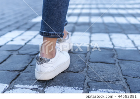 legs at a pedestrian crossing 44582881