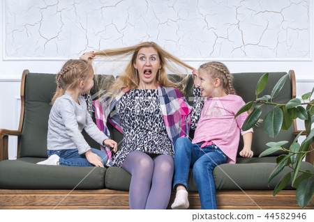 mother grimaces in front of their children 44582946