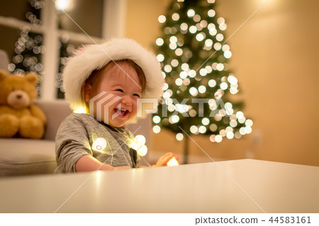 Toddler boy playing with a Santa hat at Christmas time Toddler boy playing with a Santa hat at Christmas time 44583161