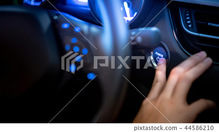 Male driver pushing car engine start button Male driver pushing car engine start button 44586210