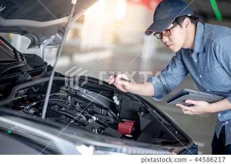 Asian auto mechanic checking the car using tablet 44586217