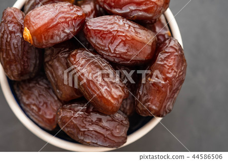 Fresh Medjool Dates in a bowl. Ramadan kareem. Black background. Top view. Copy space. Fresh Medjool Dates in a bowl. Ramadan kareem. Black background. Top view. Copy space. 44586506